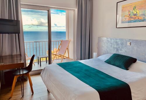 een slaapkamer met een bed en een balkon met uitzicht op de oceaan bij Il Tramonto in Calvi