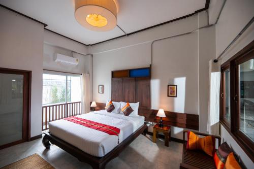 a bedroom with a large bed and a balcony at Chirin Home ฌิรินทร์โฮม in Chiang Mai