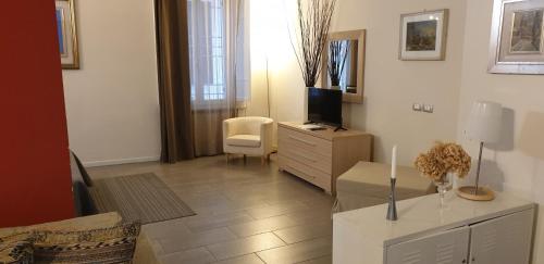 ein Wohnzimmer mit einem TV und einer Kommode mit einem tvicterictericter in der Unterkunft Agorà Residenza in Mantua