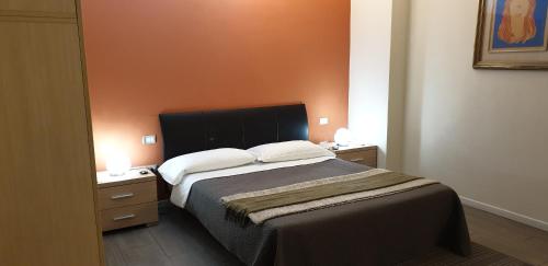 a bedroom with a large bed and two night stands at Agorà Residenza in Mantova