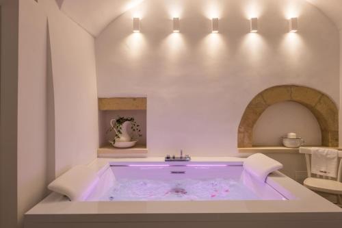 a bathtub in a white room with at Amatè Suite in Lecce