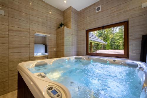a jacuzzi tub in a room with a window at Villa Vinka - Novo Zvečevo in Brestovac