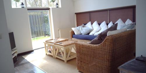 a living room with a couch and a table at Ruime comfortabele villa Ouddorp in Ouddorp