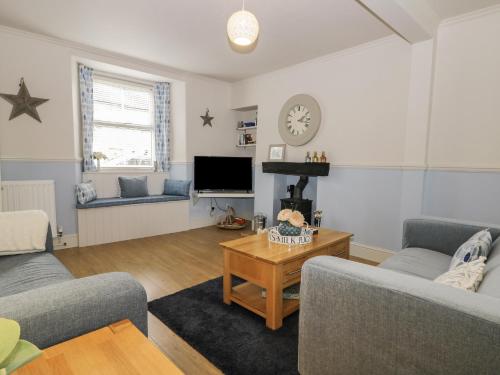 a living room with two couches and a table at Potter Hill Cottage in Pickering