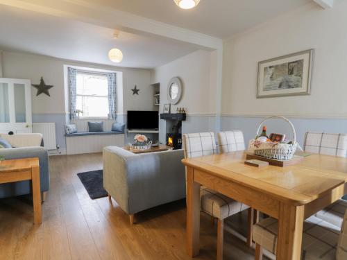 a living room with a table and a couch at Potter Hill Cottage in Pickering