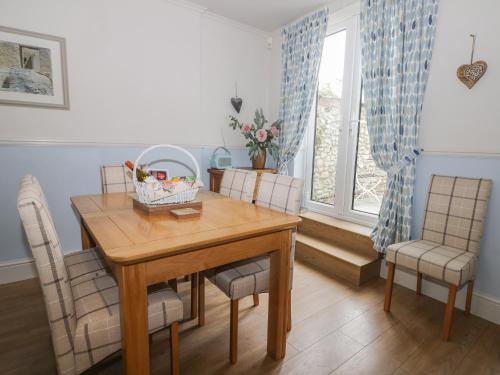 a dining room with a wooden table and chairs at Potter Hill Cottage in Pickering