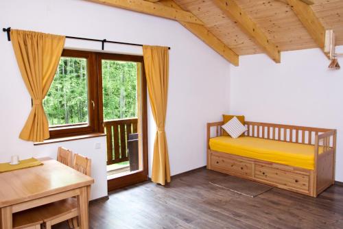 Habitación con cama, escritorio y ventana. en Penzion Albert, en Kubova Huť