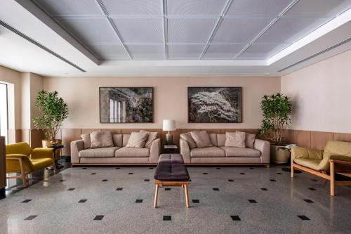 Sala de estar con 2 sofás y mesa en Regent Park Suite Hotel en São Paulo