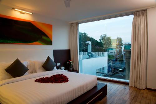 a bedroom with a large bed and a large window at Springs Hotels and Spa in Bangalore