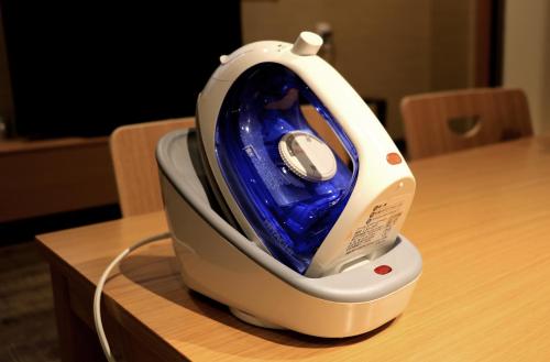 a iron sitting on top of a wooden table at Hotel Traveling Bridge Nijojo in Kyoto