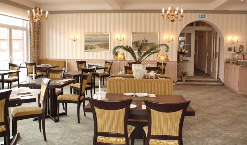 a restaurant with tables and chairs in a room at Hotel Westfalenhof in Juist