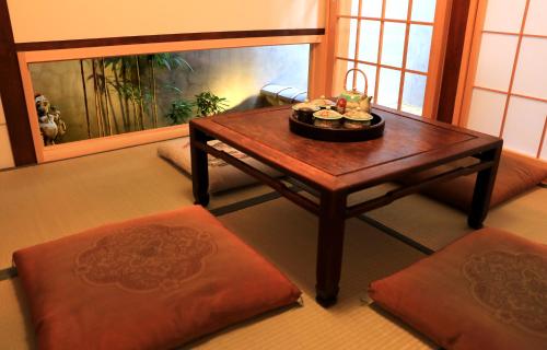 a living room with a coffee table and a fish tank at Hotel Traveling Bridge Nijojo in Kyoto