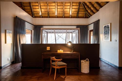 a desk with a chair in a room with a window at Tala Collection Game Reserve in Silverton
