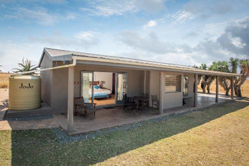 a small house with a patio and a bedroom at Tala Collection Game Reserve in Silverton