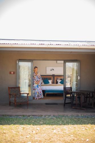 a woman standing on the porch of a house at Tala Collection Game Reserve in Silverton
