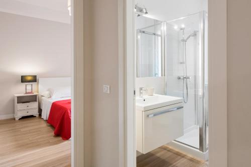 La salle de bains est pourvue d'un lavabo, d'une douche et d'un lit. dans l'établissement FLATS4RENT DIMORA DEL VIANDANTE, à Vérone