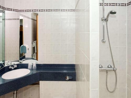 La salle de bains est pourvue d'un lavabo et d'une douche. dans l'établissement ibis Cardiff Gate - International Business Park, à Cardiff