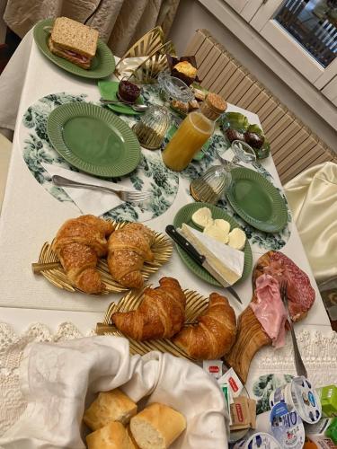 a table topped with plates of food and pastries at B&B Villa Tersius in Trezzano sul Naviglio