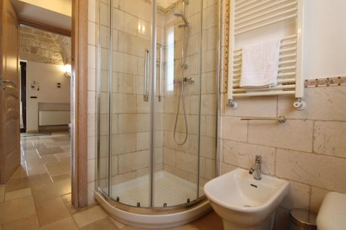 uma casa de banho com um chuveiro, um WC e um lavatório. em Villa Belvedere em Ostuni