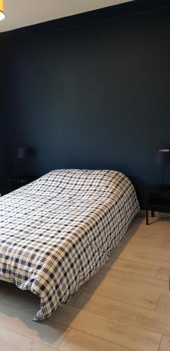 - un lit avec une couverture tressée dans une chambre dans l'établissement Le petit vosgien, à Gérardmer