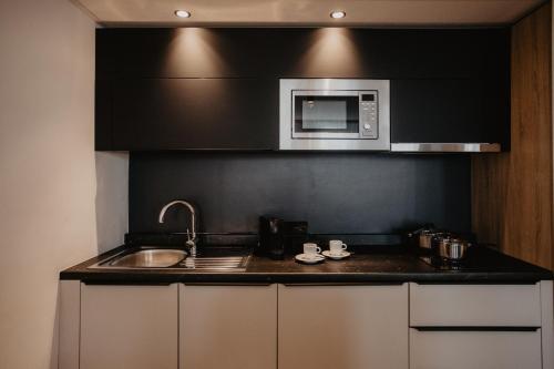 a kitchen with a sink and a microwave at Arivo Forchheim in Forchheim