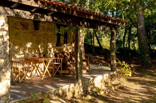 a porch of a house with a table and chairs at Forest House casinha do Carvalhal in Vila Nova de Cerveira