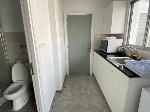 a small bathroom with a toilet and a sink at Top floor apartment in Nicosia with view! in Nicosia