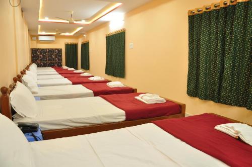 a row of beds in a hotel room at Jayaram Residency Srikalahasti in Srikalahasti