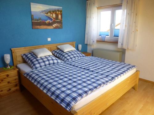 BergatreuteにあるFerienwohnung Sonnenbergのベッドルーム1室(青い壁のベッド2台、窓付)