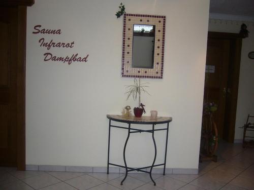 a table with a mirror on a wall at Sportpension Rubin in Sölden