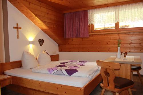 a bedroom with a bed in a wooden room at Haus Andrea in Sankt Leonhard im Pitztal