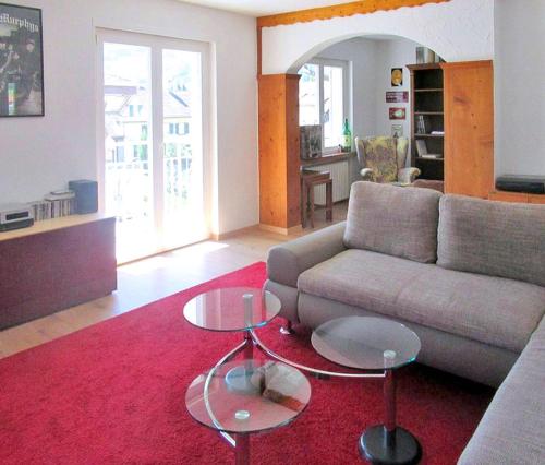 sala de estar con sofá y alfombra roja en Churfirsten Blick - Private Gästezimmer en Flums