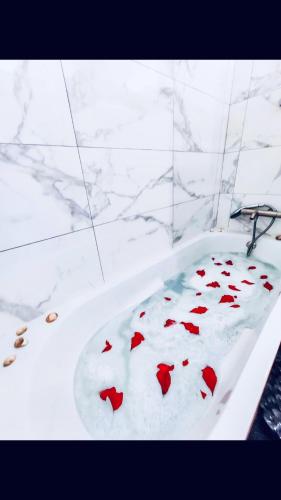 d'une baignoire blanche avec coeurs rouges. dans l'établissement Cosy Appart Hotel Boulogne -Paris, à Boulogne-Billancourt