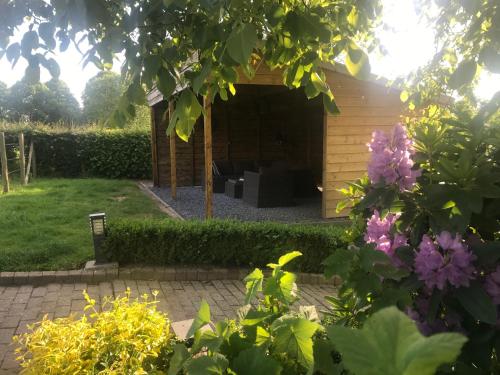 a garden with a pavilion in the background at 't Reijmerhöfke in Reijmerstok
