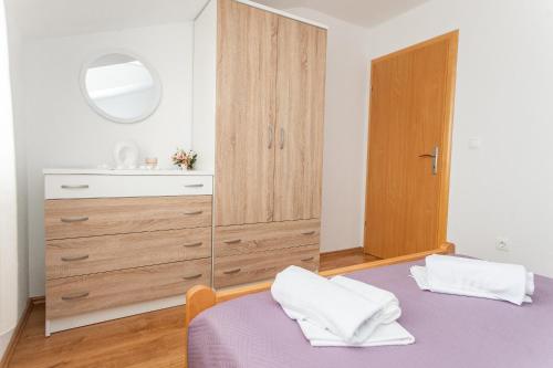 a bedroom with a bed and a dresser with a mirror at Villa Verbena in Mala Čista