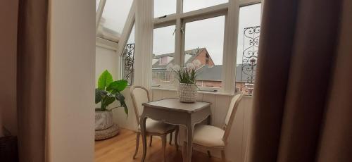 a table and chairs in a room with a window at Hendrika Apartments in Zandvoort