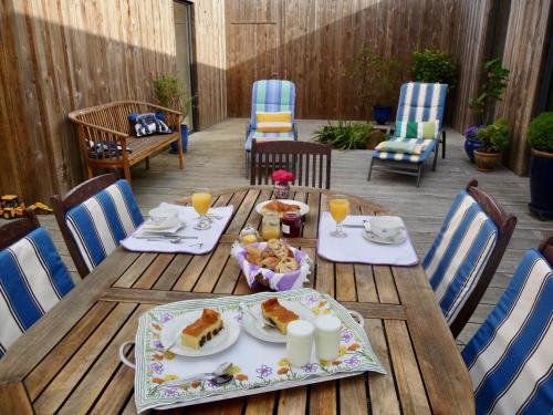 a wooden table with food and drinks on a patio at La Miellerie in Lannion