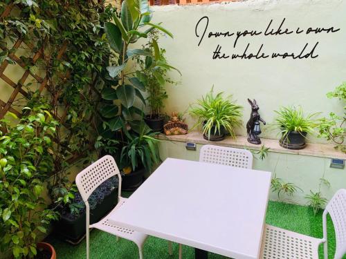 a table and chairs in a garden with a sign that reads your life is now at Babyface in Rome