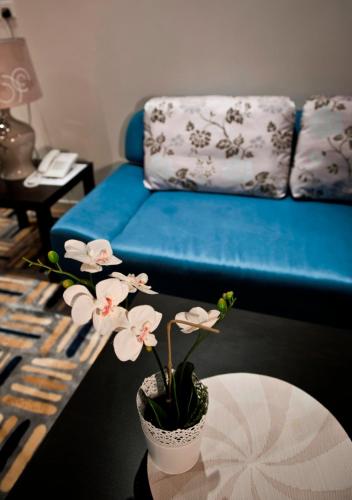 a vase with flowers on a table in a living room at الأجنحة التنفيذية للشقق المخدومة - اقتصادي in Riyadh