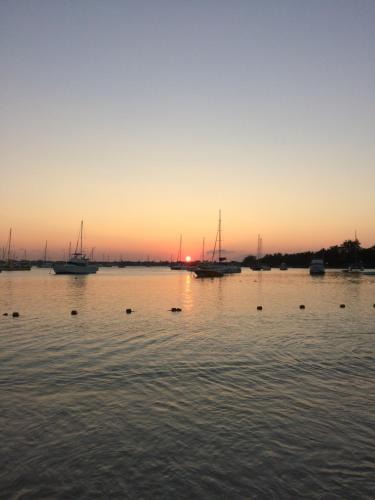 a group of boats in the water at sunset at Ebrahim Flats - Grand Baie Beach in Grand Baie