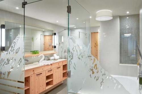 a bathroom with a shower and a sink at Vitalpina Hotel Magdalenahof in Santa Maddalena