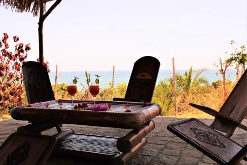 a table with two glasses of wine sitting in chairs at Le Grand Bleu in Andilana