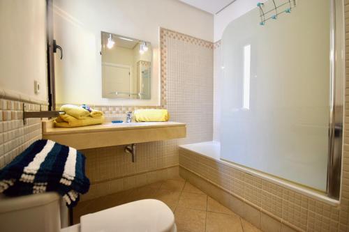 a bathroom with a toilet and a sink and a tub at Casa Vivien in Playa Blanca