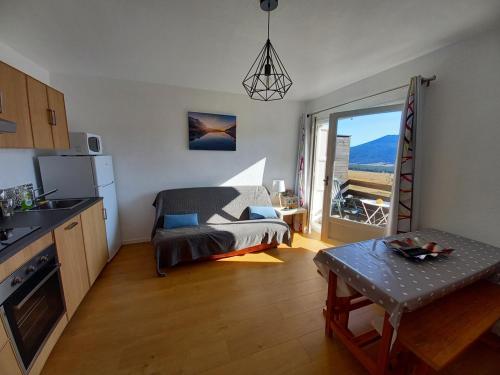 uma cozinha e sala de estar com um sofá e uma mesa em Appt T2 & Cabine - Superbe vue - WIFI em Les Angles