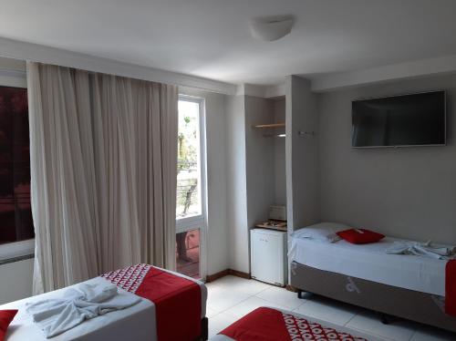 a hotel room with two beds and a window at Hotel Santiago in Salvador