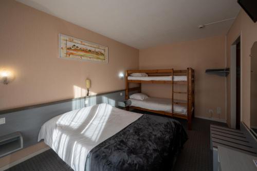a hotel room with a bed and bunk beds at Hôtel du Soleil Levant in Argelès-Gazost