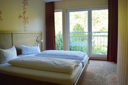 a bedroom with a bed and a large window at Sonnenhof-Willingen in Willingen