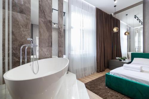 un bagno con vasca accanto a un letto di Avangard Green Park Art Apartment a Lviv