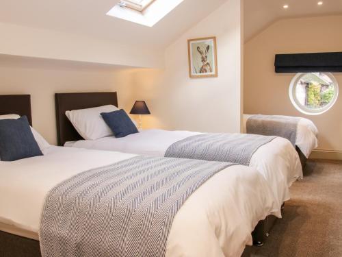two beds in a room with a window at Conkers' Cottage in Church Stretton