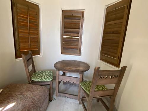 a room with two chairs and a table and two windows at Villa Rosa Inn in Santa Barbara